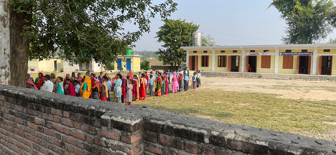 Kolmuda community standing outside the school