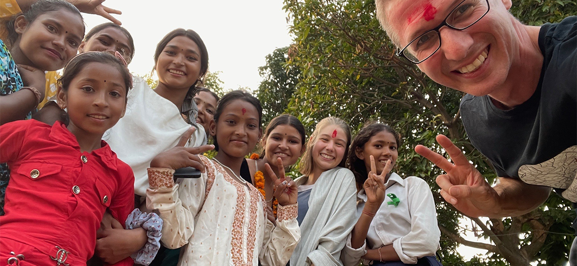 Martin and Lucie posing for a group photo with the young girls of the community
